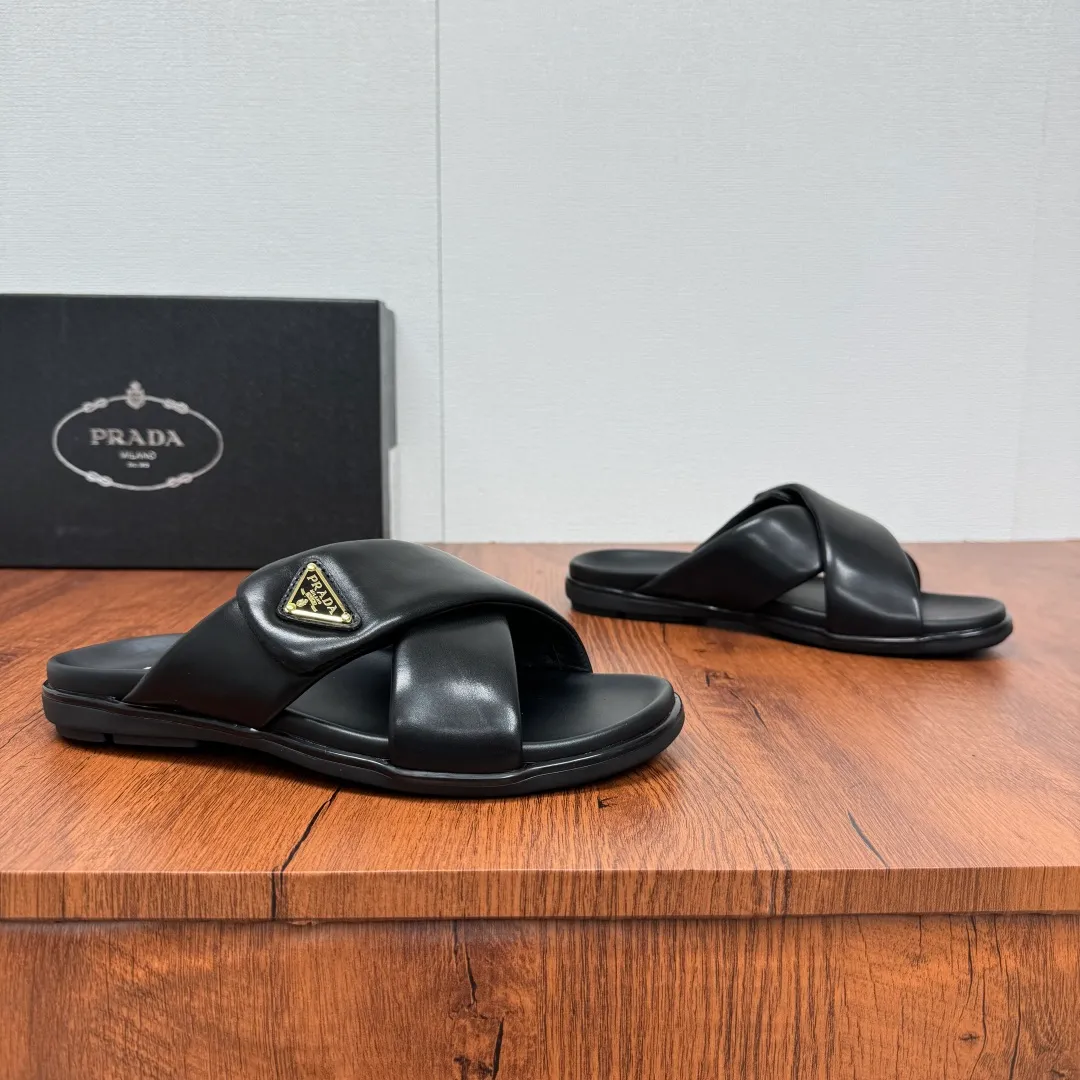 Batch 580 Prada/Prada's new men's leather cross slippers. Velcro closure can finely adjust the size. Calf leather light luxury slippers. Thick soft calf leather wraps the upper. Fat but soft rubber lazy style, soft and comfortable, excellent foot feel. Genuine leather bottom layer, cross style, with a Velcro closure buckle, easy to adjust the appropriate size, and a perfect fit for the wearing experience. The enamel gold triangle logo highlights the brand's classic features. Lightweight rubber thin sole, high foot comfort! Complete package! Size: 39-40-41-42-43-44-45 Leather shoe size Item number: 2X7132 Black